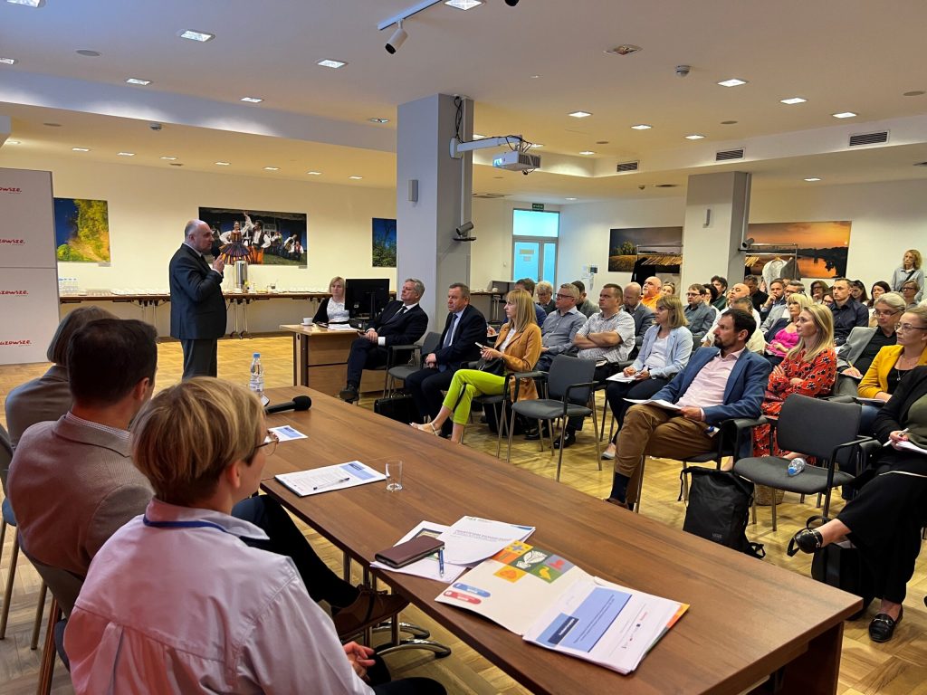Zdjęcie przedstawia ludzi na konferencji