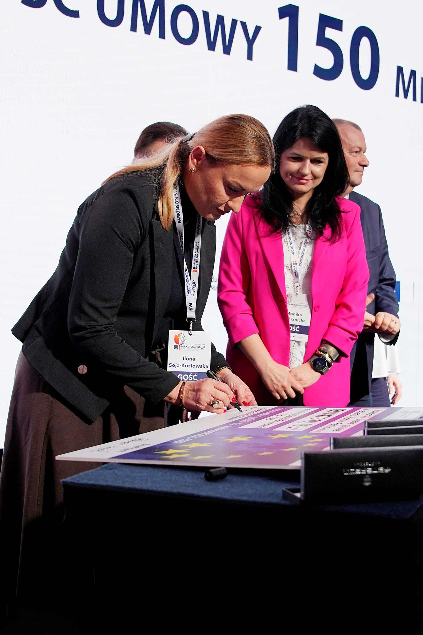 Dyrektor MJWPU Ilona Soja Kozlowska na podpisuje symboliczny czek na zakonczenie konferencji