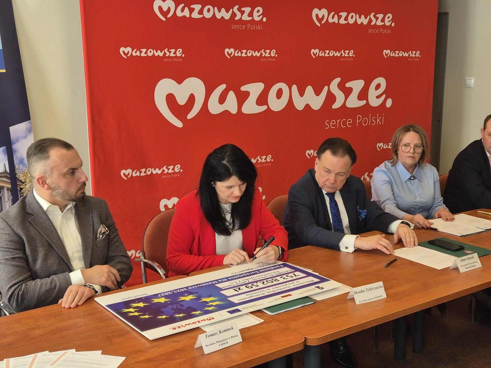 Monika Tchorznicka zastepca dyrektora MJWPU podpisuje symboliczny czek