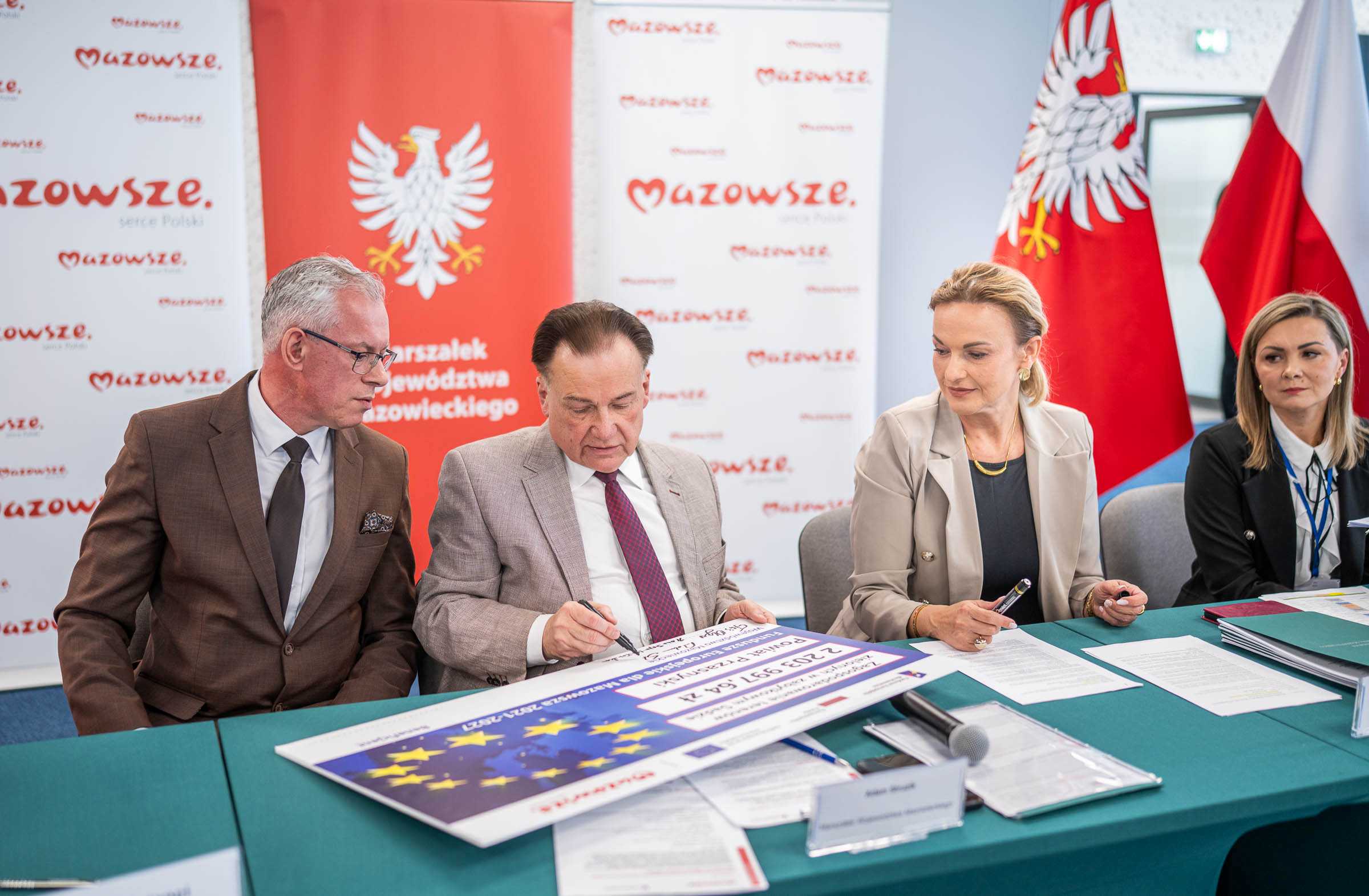 Marszalek A. Struzik podpisuje symboliczny czek na konferencji w Ciechanowie