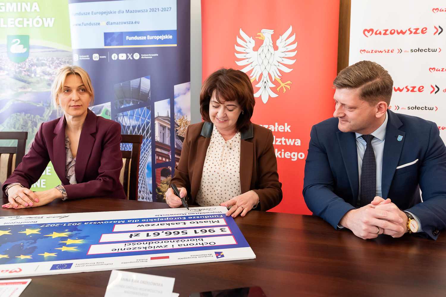 Czlonkini zarzadu J.E. Orzelowska podpisuje symboliczny czek blisko 4 mln zl