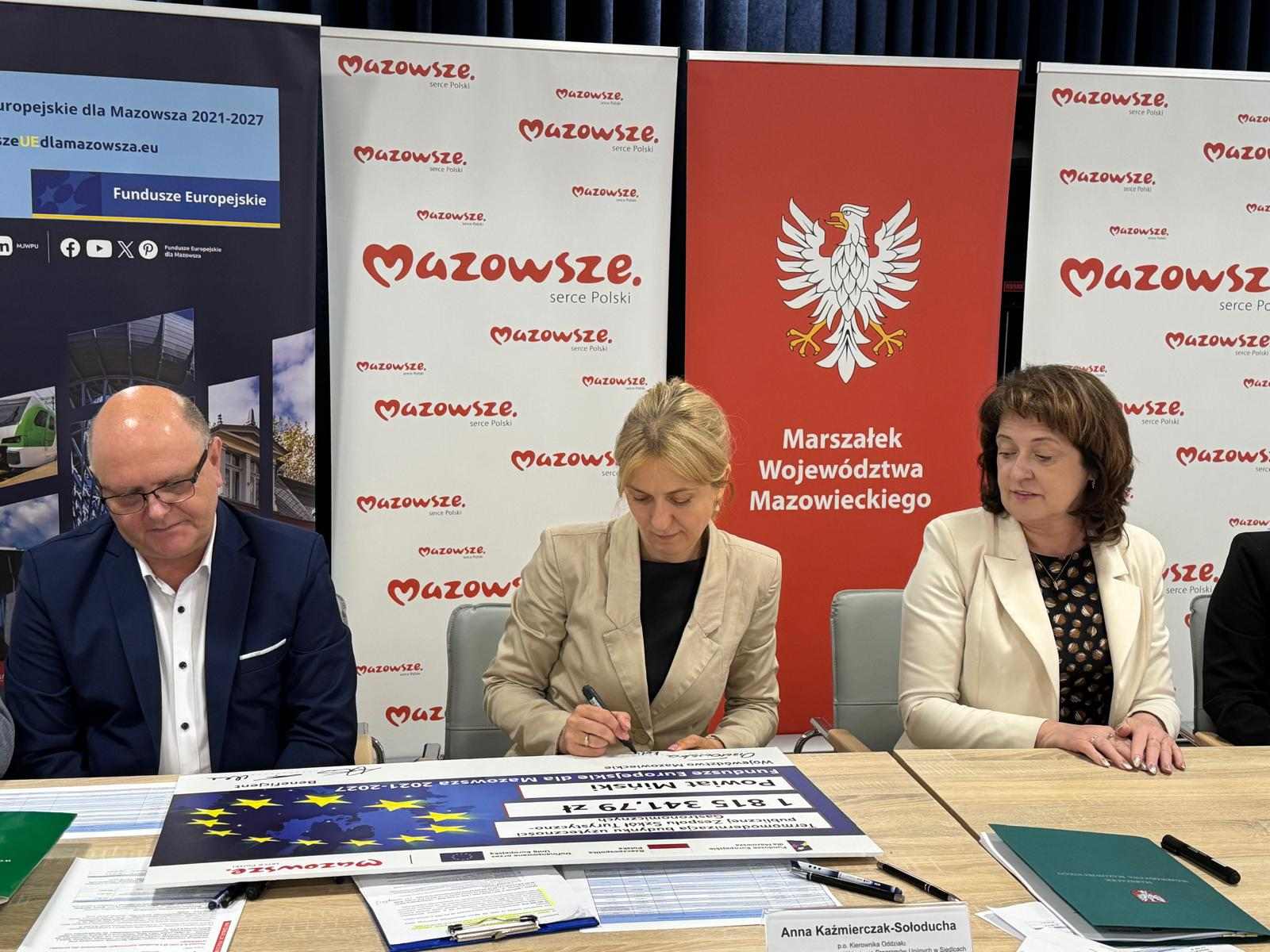 Beneficjent podpisuje symboliczny czek