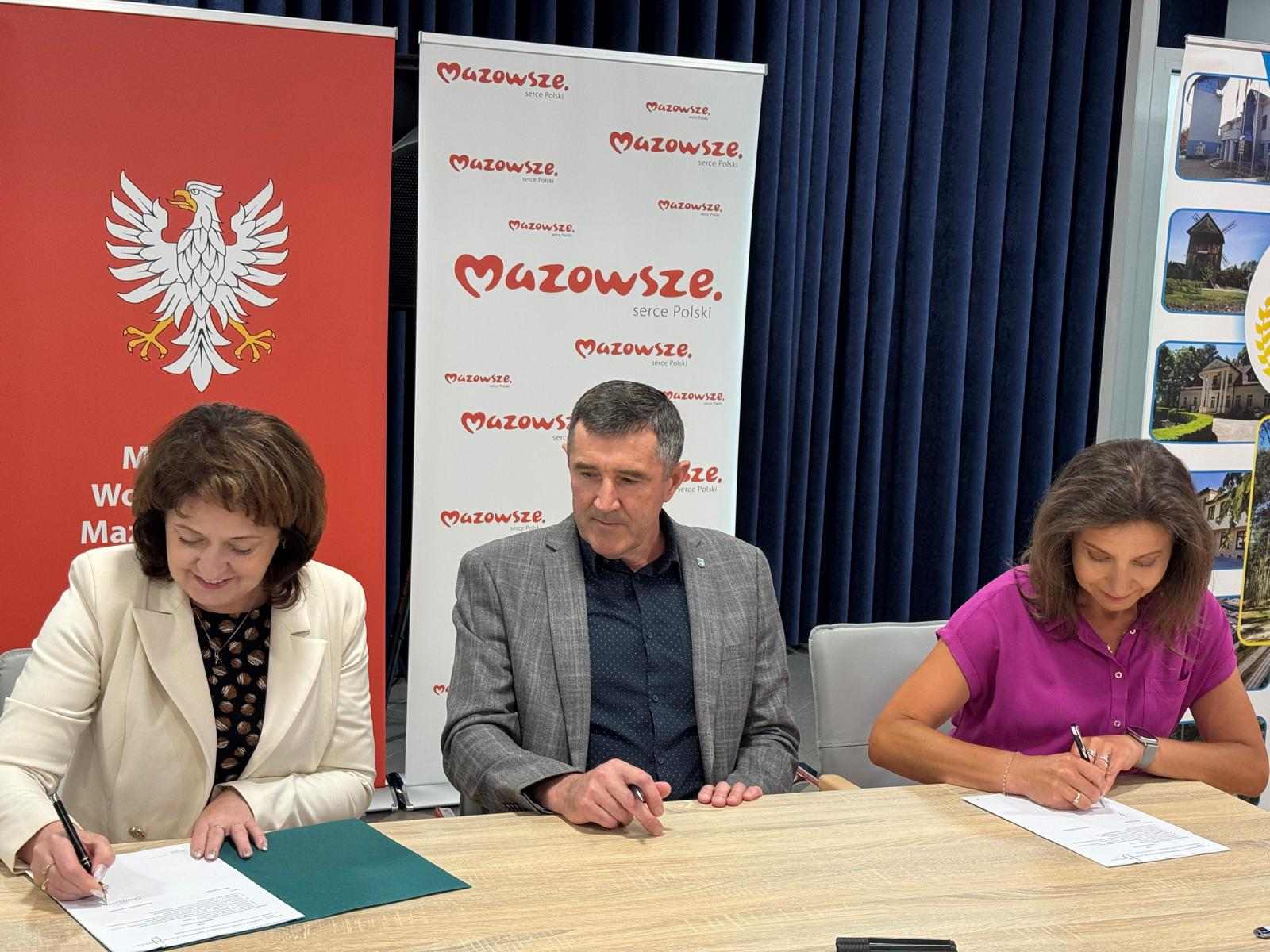 Czlonkini zarzadu J. E. Orzelowska oraz beneficjenci podpisuja umowe o dofinansowanie