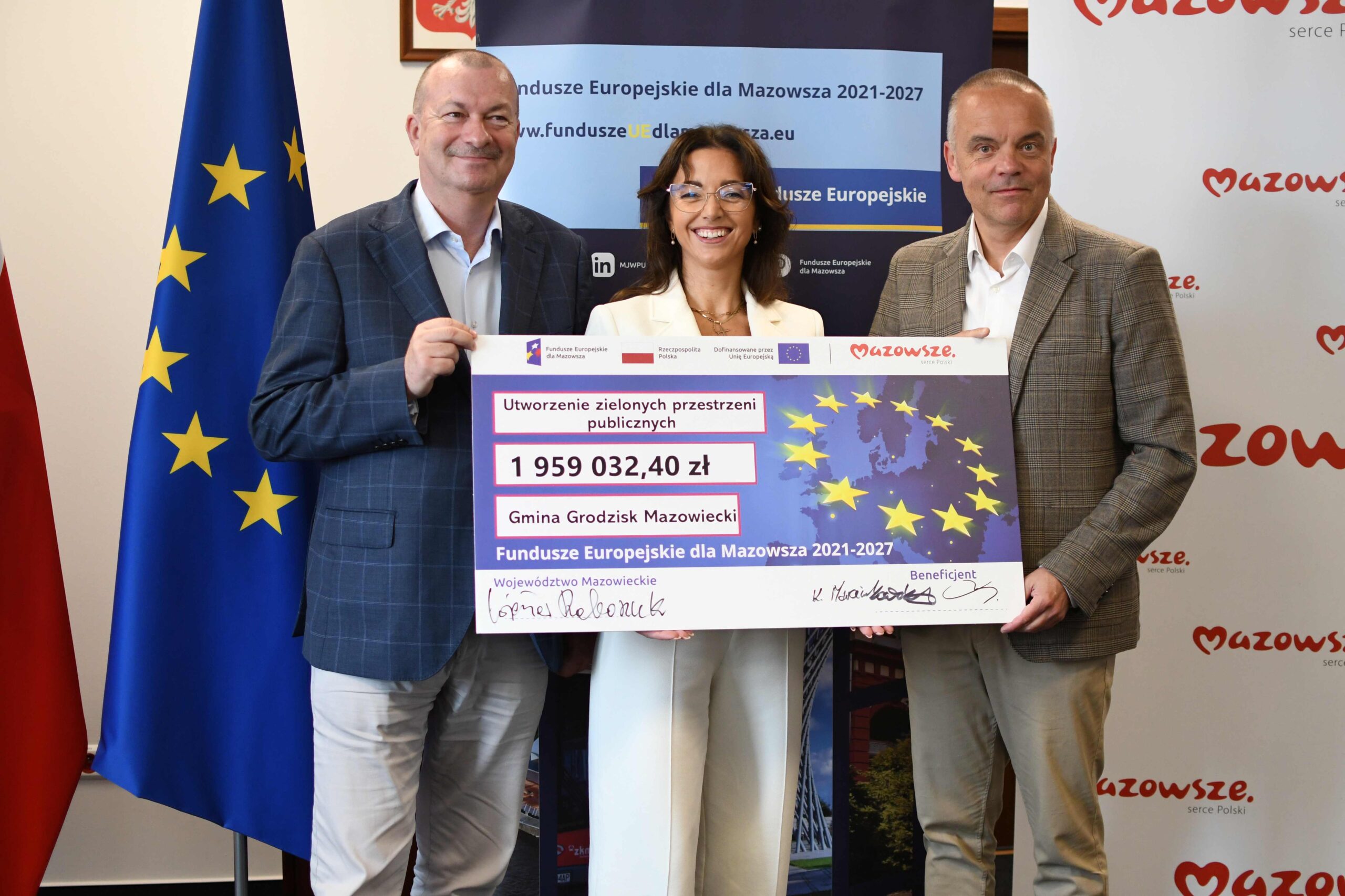 Wspolne zdjecie z pamiatkowym czekiem na spotkaniu w UM WM w Warszawie scaled