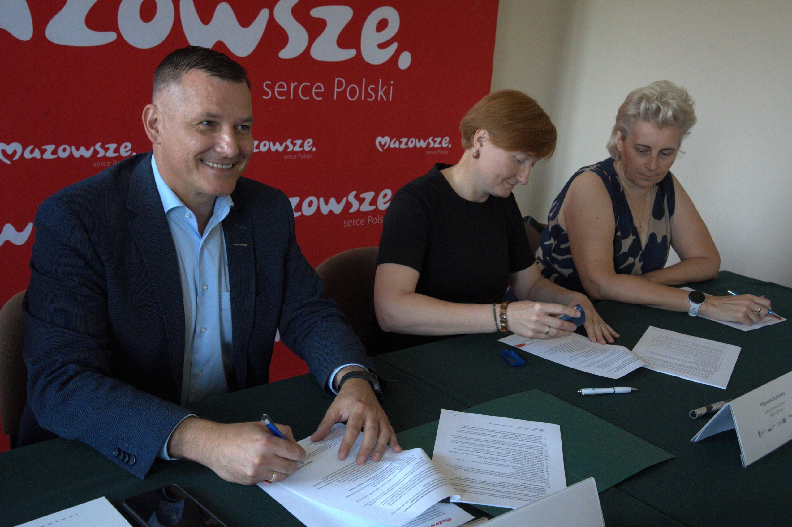 Wicemarszalek R. Rajkowski podpisuje umowe w towarzystwie beneficjentow scaled