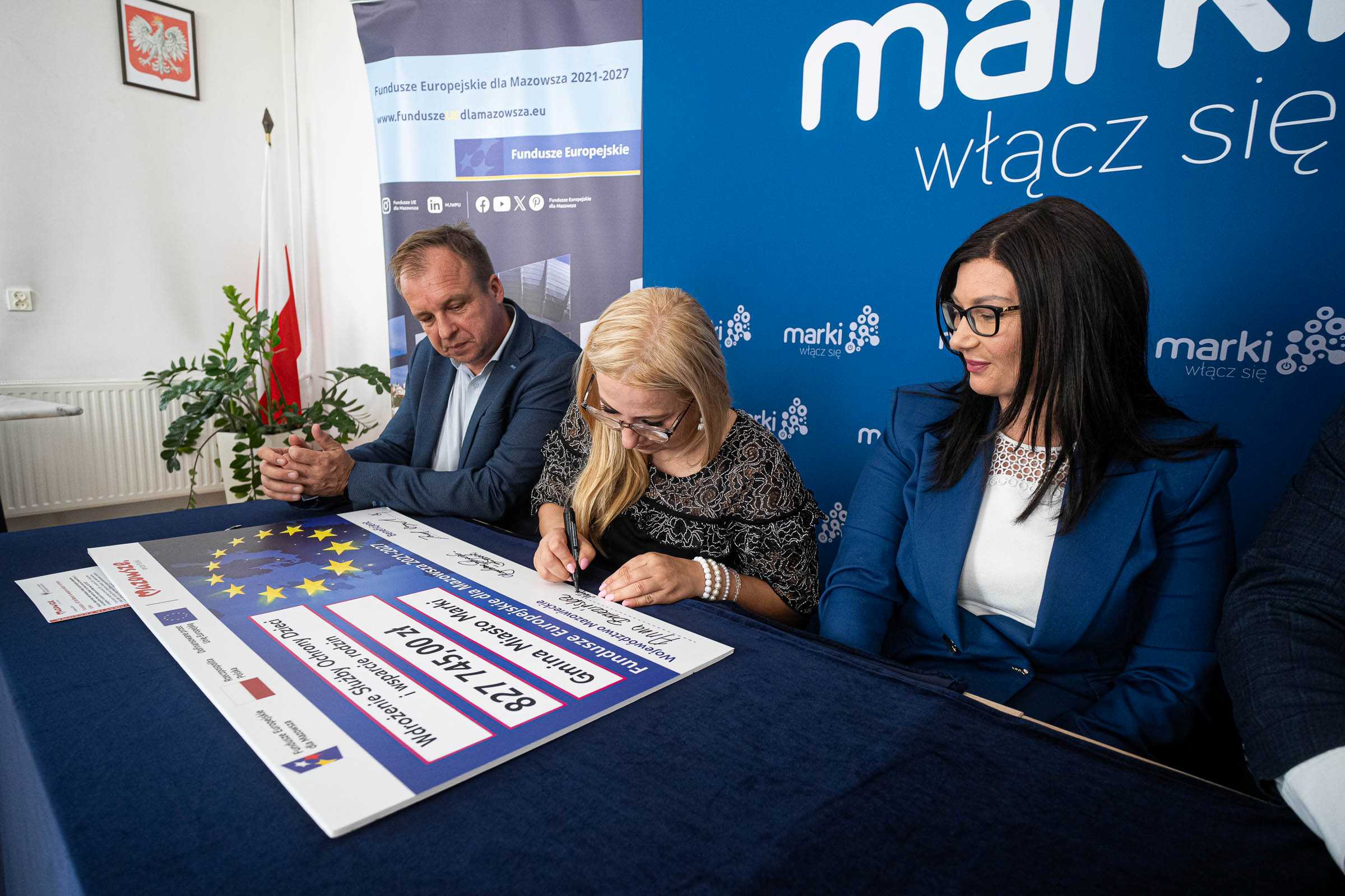 Kierownik M. Grabkowska podpisuje czek
